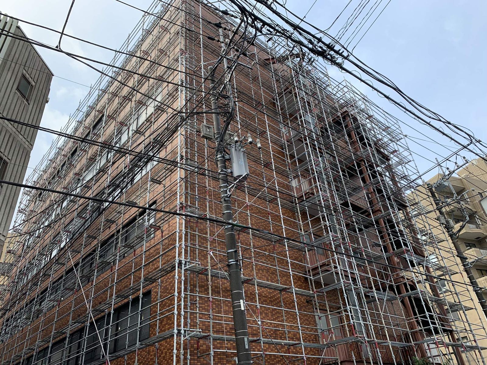 建物の外周に足場を組んだ改修工事の現場